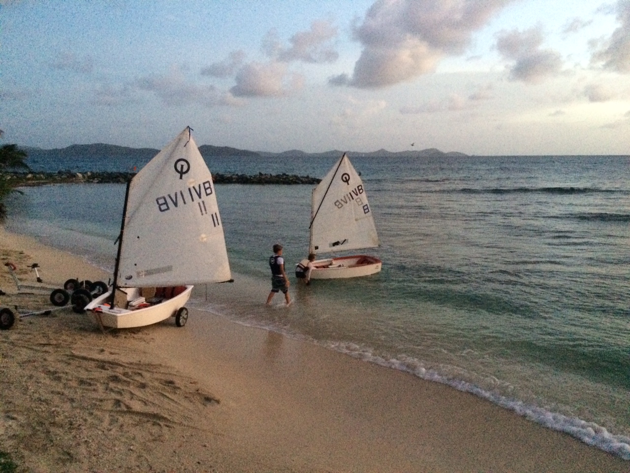 Two small sailboats coming to shore in the British Virgin Islands