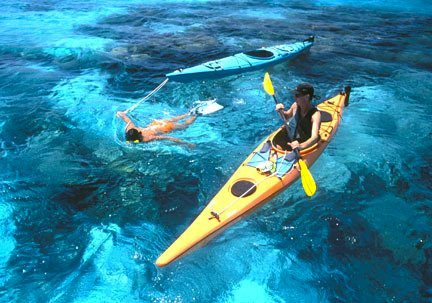 Couple kayaking and snorkeling in clear blue water of Belize