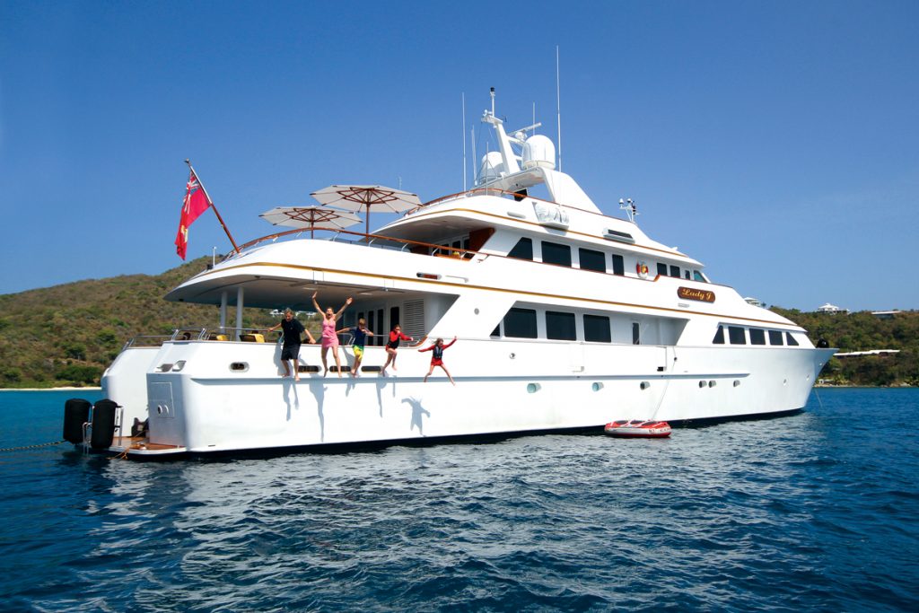 Happy family jumping into the water from the motor yacht LADY J