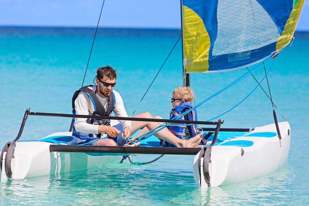 father and son, enjoying sailing together at hobie cat catamaran