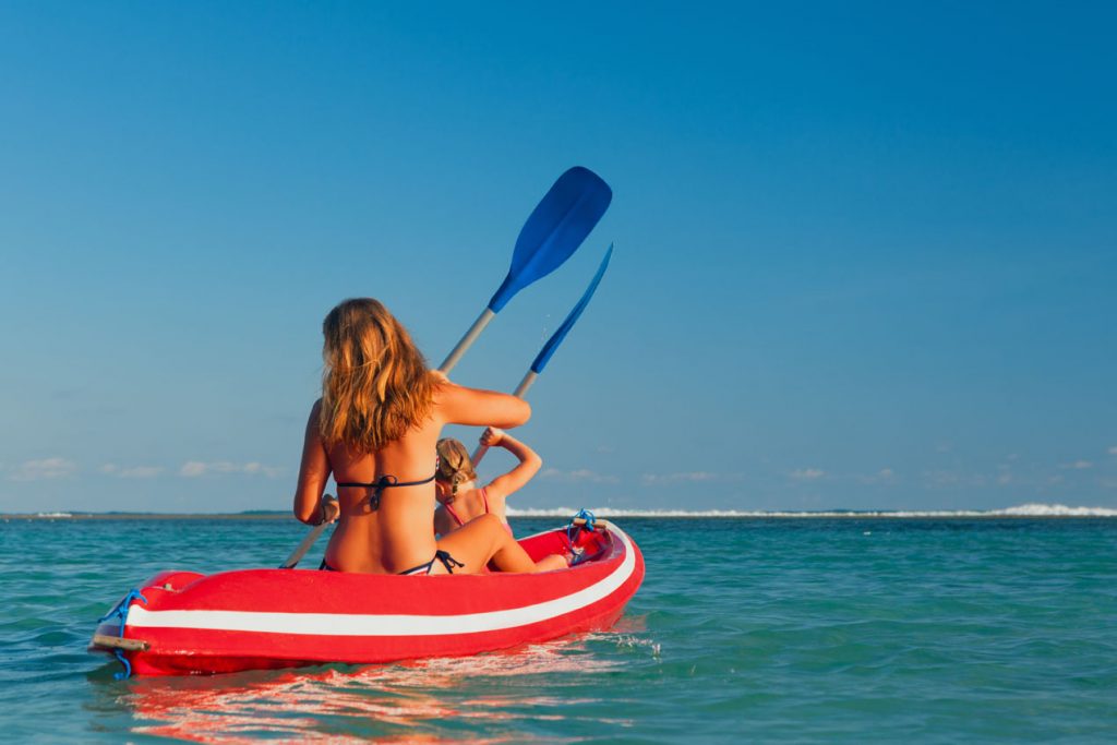 Mother and daughter paddling in a kayak in The Caribbean