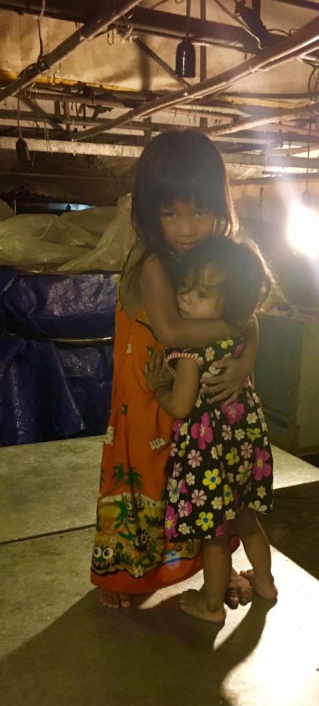 Two young girls hug at Night Market in Phnom Penh, Cambodia