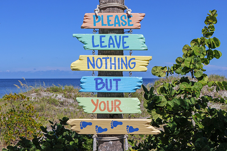 Beach sign saying, "Please leave nothing but your footprints."