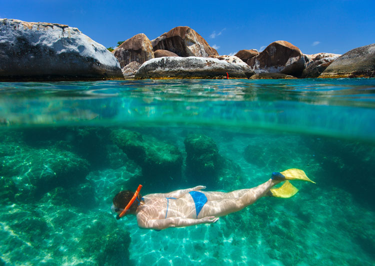 Split photo of young woman snorkeling in turquoise ocean water on Virgin Gorda, British Virgin Islands, Caribbean