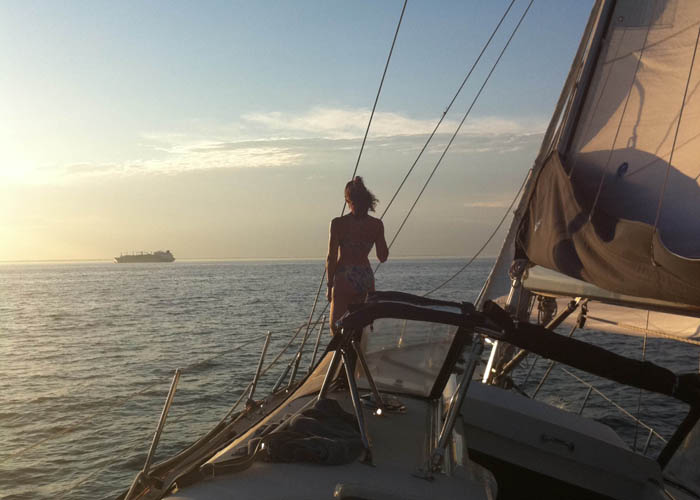 Woman looking out to sea from the bow of the sailing yacht INDEPENDENCE