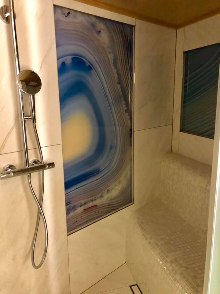 Shower with two huge slices of blue and yellow geode encase in a shower wall on the sailing yacht AIAXAIA 2018 MYBA Charter Show