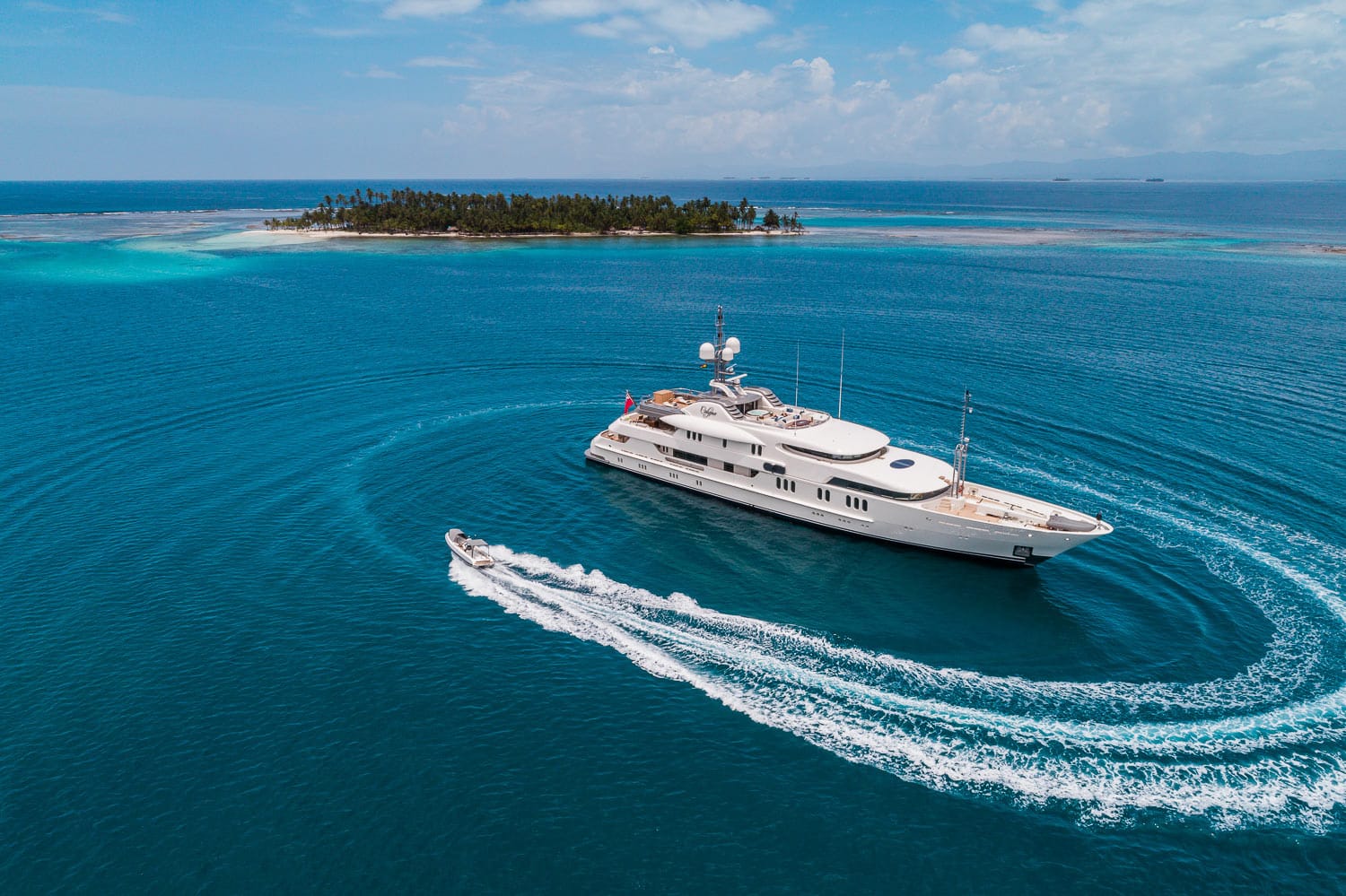 Aerial view of 202ft Amel motor yacht CALYPSO w tender circling boat