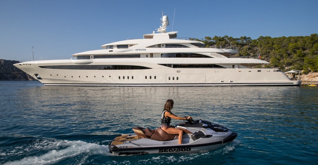 MainShot 279ft Golden Yacht motor yacht O'ptasia with women on jet ski. Operating in the East Mediterranean, West Mediterranean, Arabian Gulf, Caribbean and the Indian Ocean