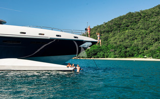 Charterers leap into the clear blue water from the bow of 114ft M/Y SPIRIT, a Bakewell-White Yacht Design motor yacht.
