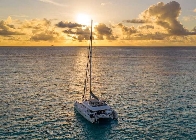 62ft Lagoon sailing catamaran TWIN FLAME on the water during golden sunset