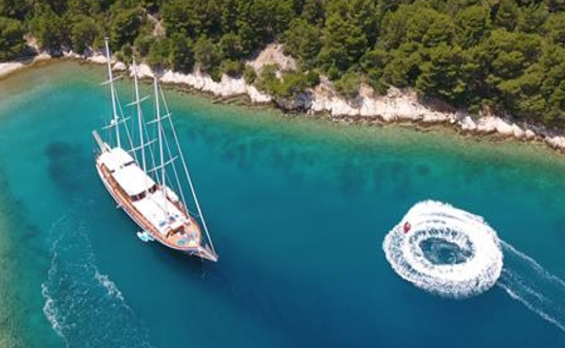 Aerial view of 112ft custom sailing yacht DOLCE VITA in lagoon with jet ski circle