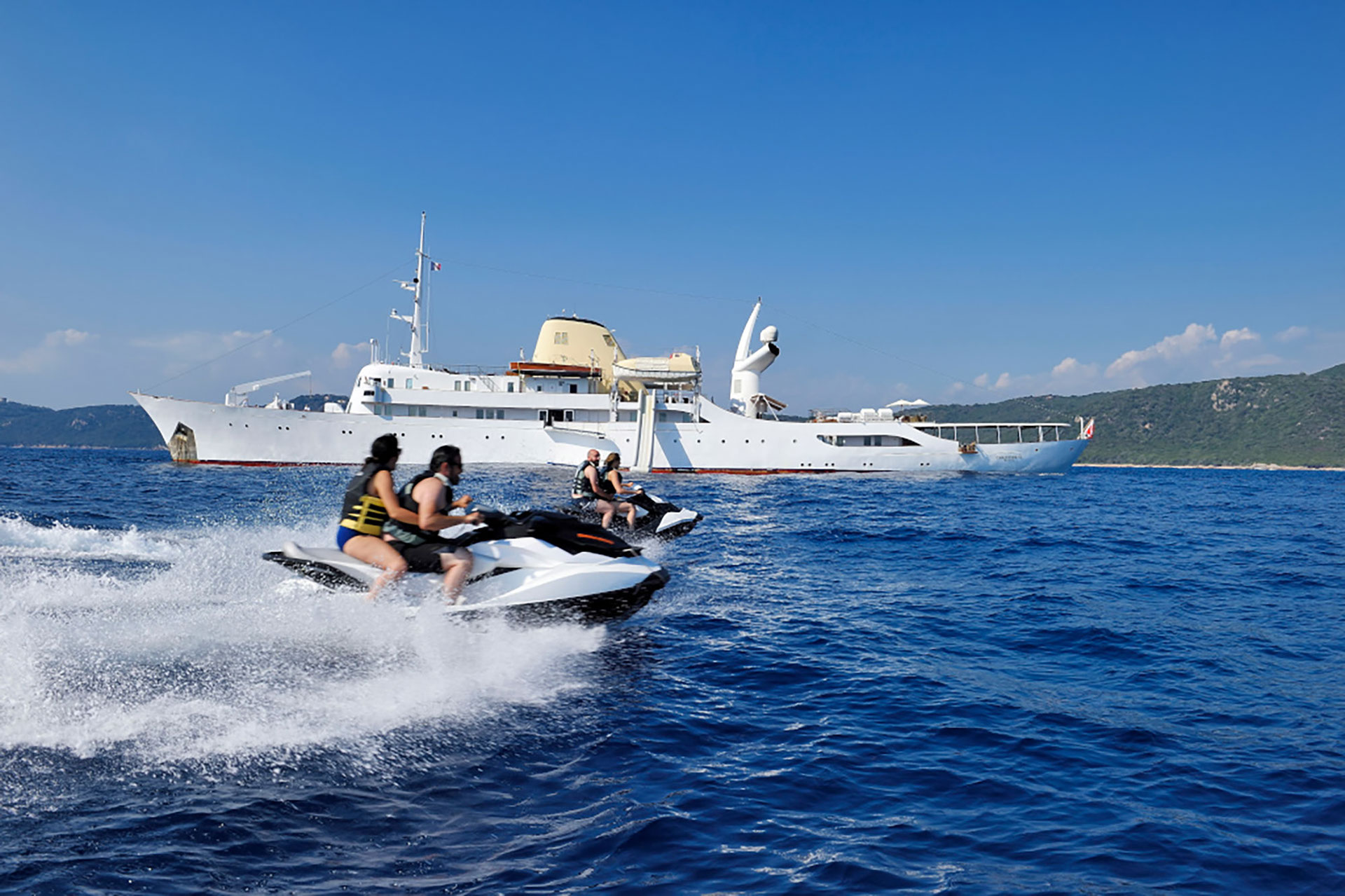 Couples zooming by 325ft superyacht M/Y CHRISTINA O on her jet skis