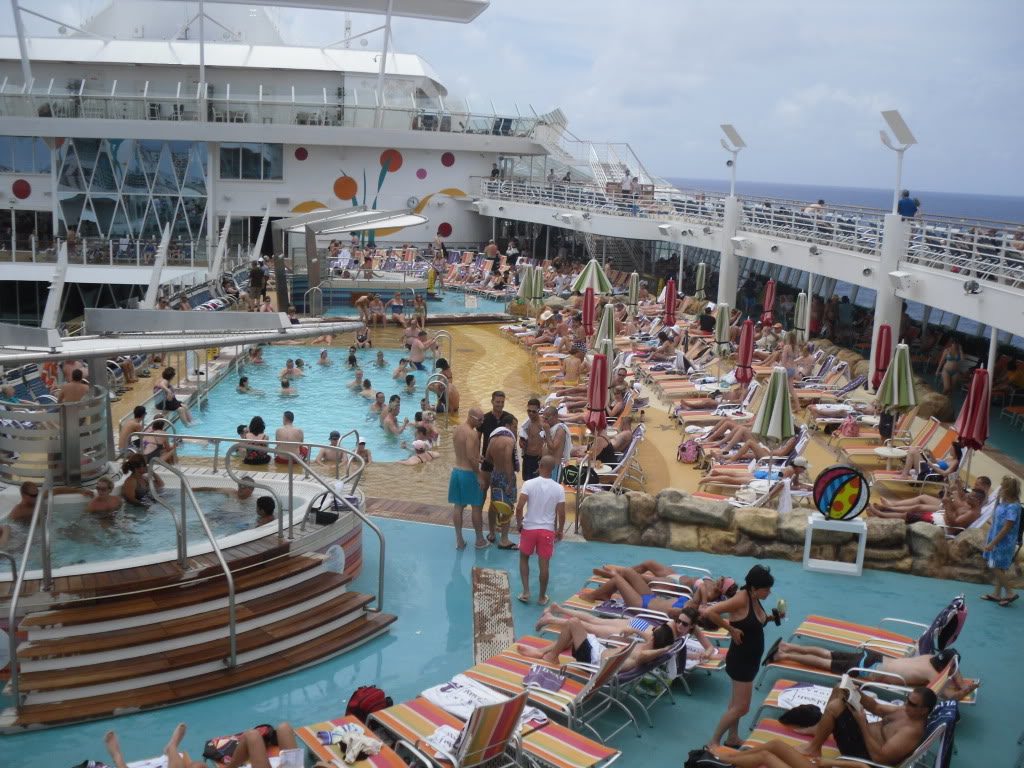 Cruise ship with crowded decks and pool on gray day. Photo©CarolKent