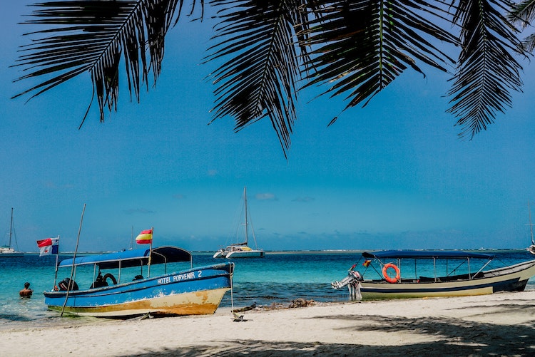 Boats on and off one of Panama's white sandy beaches