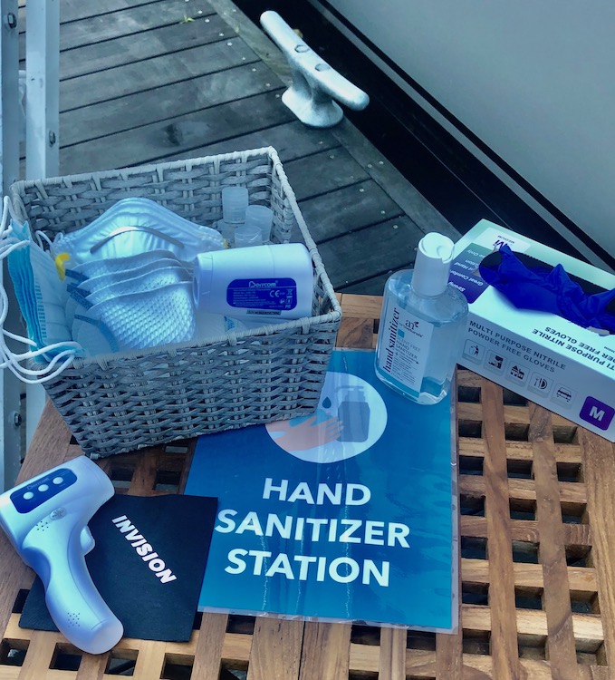 Masks, gloves, thermometer and hand sanitizer station aboard a charter yacht