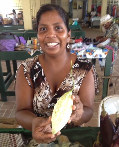 A vegetable vendor in a St. Barths market presents her beautiful native produce