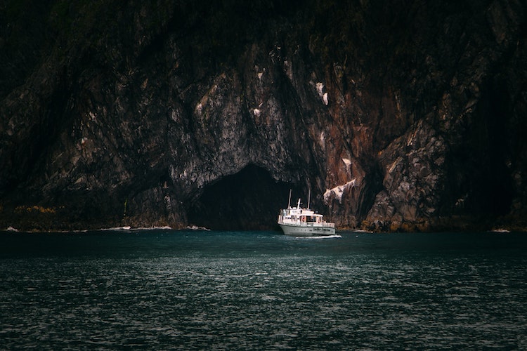 Yacht at mouth of cave in Alaska