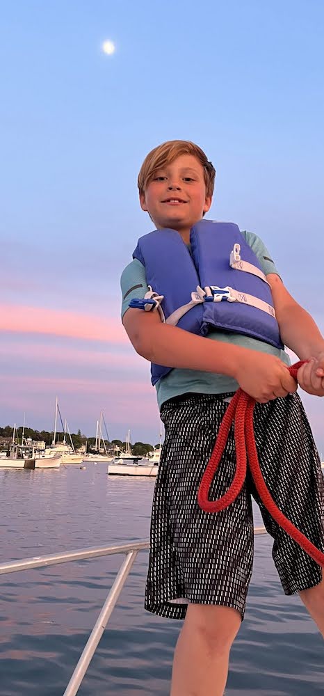 Young Boy learning the ropes on a boat. Photo by Carol Kent. Yachting with youngsters and teens.