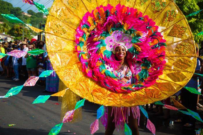 Spice Mas Carnival goer in Grenada with big yellow flower around her face