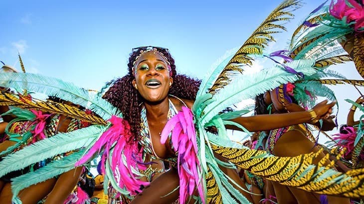 Woman in colorful festival feathers for National Carnival Sugar Mas on St. Kitts-Nevis. Photo courtesy of StKittsTourism.kn