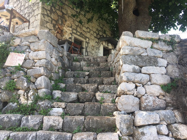 Stone steps and cafe sign at Kotor fortress in Montenegro. Photo©carolkent.com