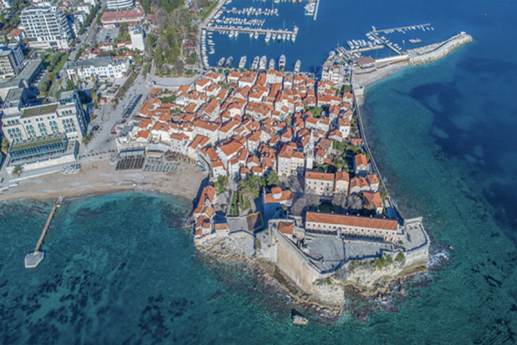 Aerial view of red-roofed buildings and harbor at Budva, Montenegro
