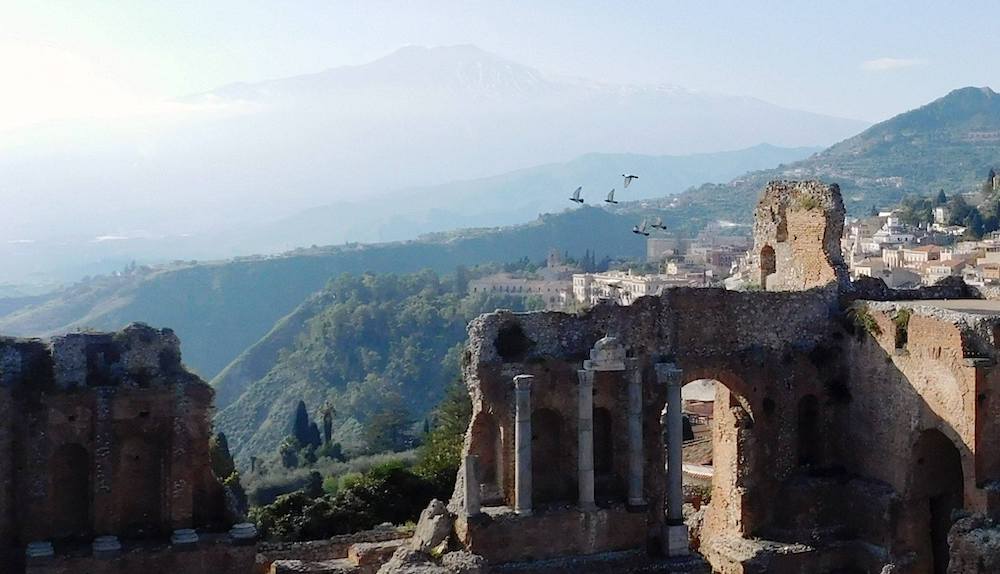 Doves alight from Teatro Greco overlooking Mt. Etna in Taormina, Sicily photo©TravelOggyLajla