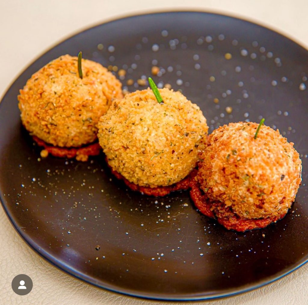 Risotto rice cooked and formed into golf-size balls, stuffed with mozzarella cheese, sundried tomatoes and rolled in egg batter with a Parmesan, garlic, breadcrumb coating with pumpkin by Sophia Ribiero, chef of 67ft C'est La Vie