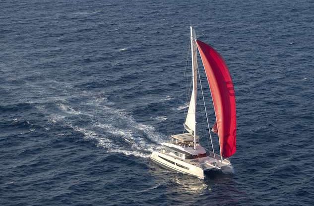 67ft Fontane Pajot sailing catamaran FLORAMYE at sea with red sail